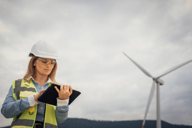 istock A skilled female engineer inspects a wind turbine with her tablet, checking maintenance and efficiency, showcasing her expertise in sustainable technology and renewable energy innovation 2174839082