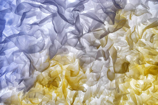 istock Abstract background with elegant tissue paper clouds in soft blue and yellow tones placed on a white light background 2174839654