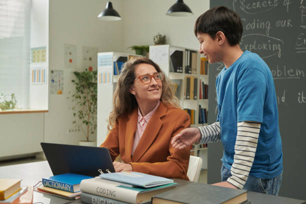 istock Smiling Teacher Talking to Child in School 2174839970