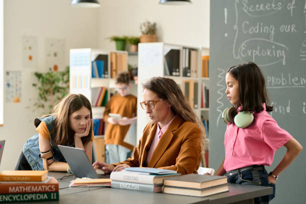 istock Two Girls Talking to Teacher 2174839972
