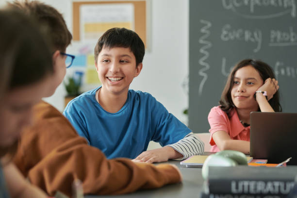 istock Smiling Boy Talking to Friends During Class 2174839988