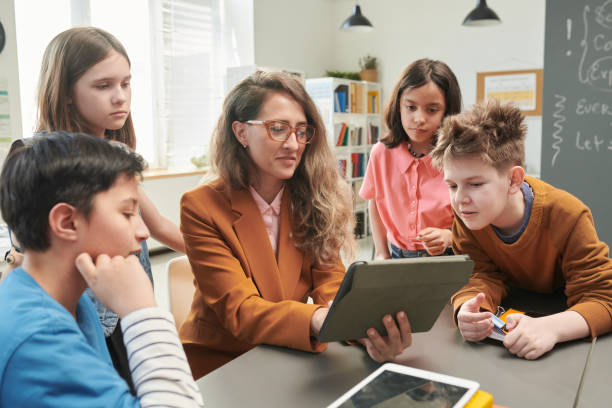istock Teacher using Tablet with Group of Children 2174840013