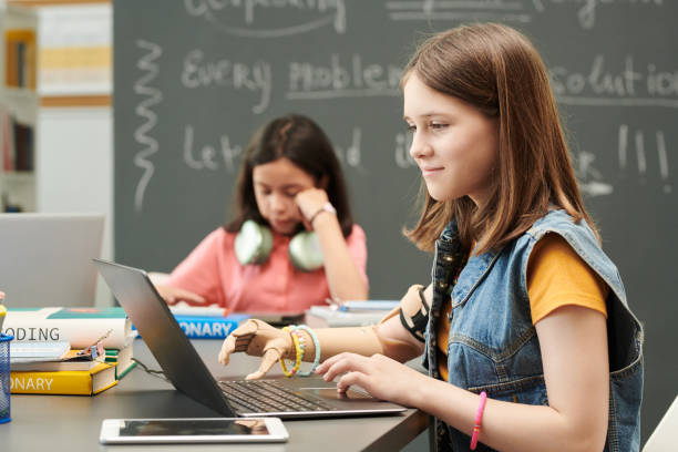 istock Girl with Prosthetic Arm using Laptop 2174840082