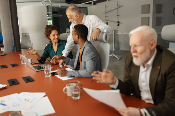 istock Coworkers engage in teamwork around a laptop 2174841645