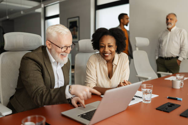 istock Two colleagues discussing work on laptop together 2174841701