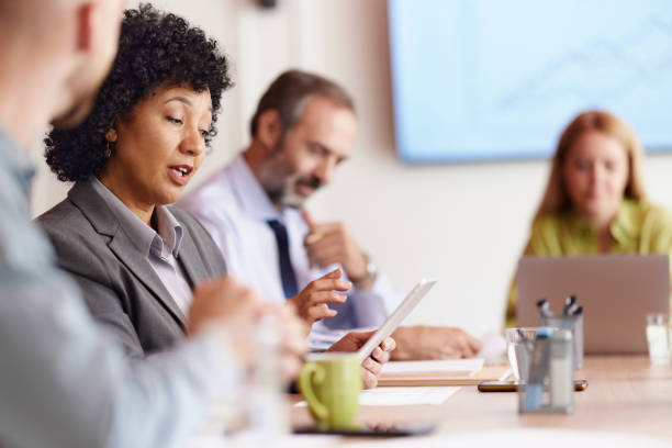 istock Multiracial businesswoman using touchpad while talking to her colleague in the office. 2174842108