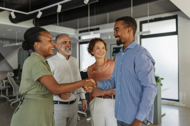 istock Two colleagues enthusiastically shaking hands in office. 2174844566