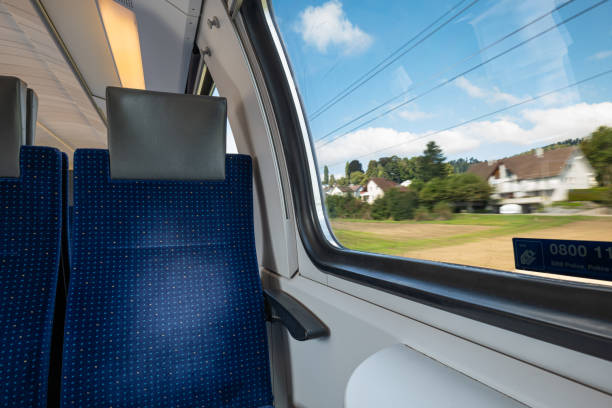 istock Empty seats in a public passenger train in Switzerland, Europe. Wide angle, natural window light, no people 2174846802
