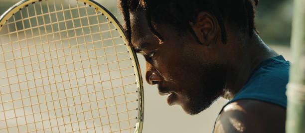 istock Focused African-American man with dreadlocks holding a tennis racket 2174848103