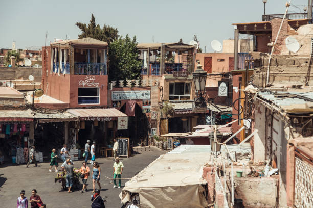 In the heart of Marrakesh, Morocco, a lively marketplace showcases a blend of residential and commercial buildings