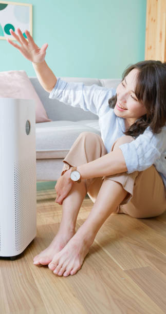 istock woman use air purifier home 2174852625