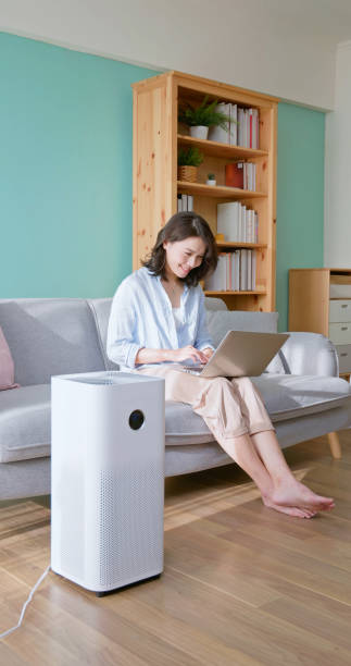 istock woman use air purifier home 2174854432