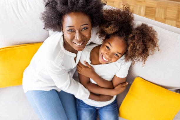 istock Mother and Daughter Smiling Together on a Cozy Sofa 2174858978