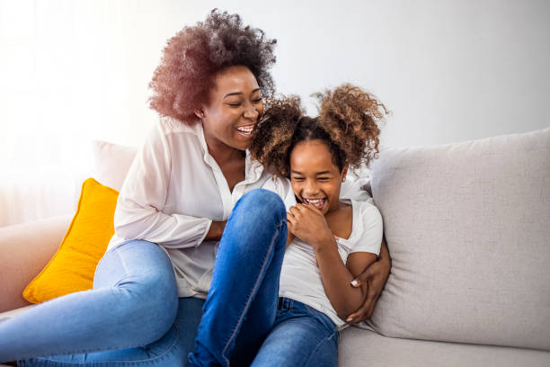 istock Happy Mother and Daughter Laughing on a Cozy Sofa 2174858998