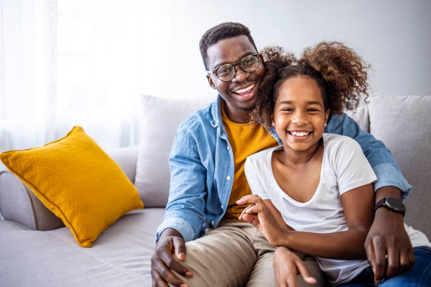 Happy Father and Daughter Smiling Together on Couch