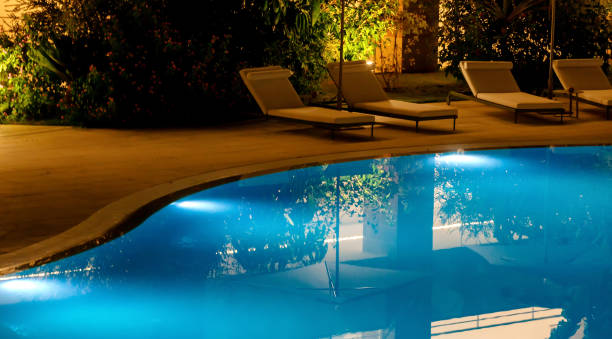 istock Luxurious illuminated swimming pool reflecting trees at night 2174861623