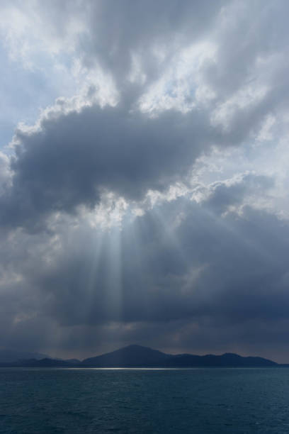 View of mountain ridge on horizon under cloudy sky at dawn