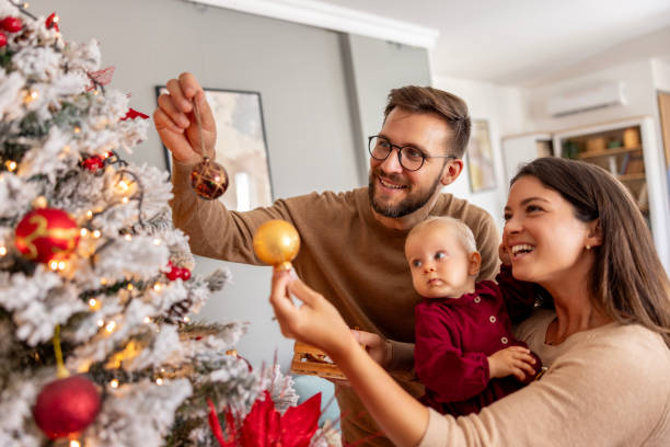 istock Young family decorating Christmas tree 2174873182