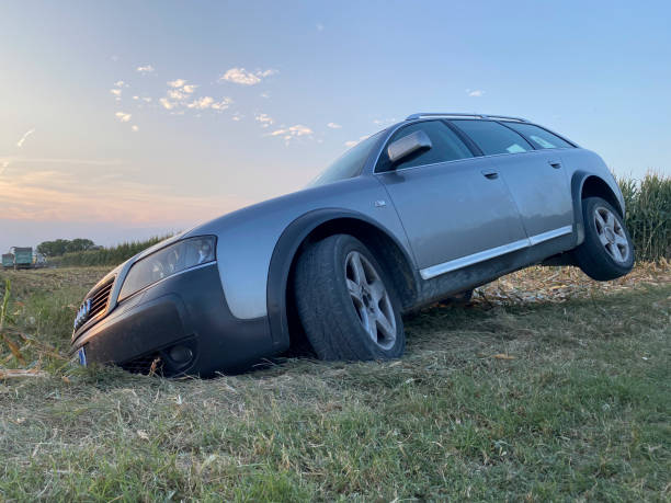 Cremona, Italy July 19th 2024 Audi a6 allroad car stuck in a ditch after a wild drive through a cornfield at sunset, highlighting the need for help and responsibility in unexpected situations