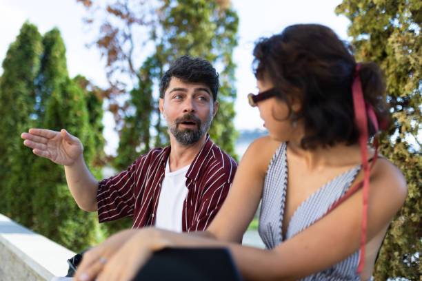 istock Casual conversation between friends outdoors on a sunny day, with a relaxed atmosphere and green trees in the background. 2174874650