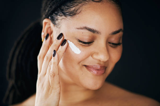 istock Happy Woman Applying Face Cream in Skincare Routine 2174876348