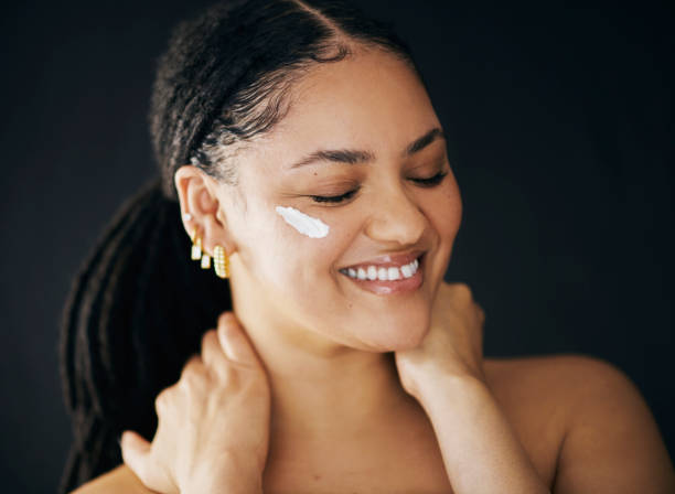 istock Happy Woman Applying Face Cream in Skincare Routine 2174876351