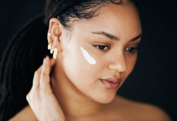 istock Happy Woman Applying Face Cream in Skincare Routine 2174876369