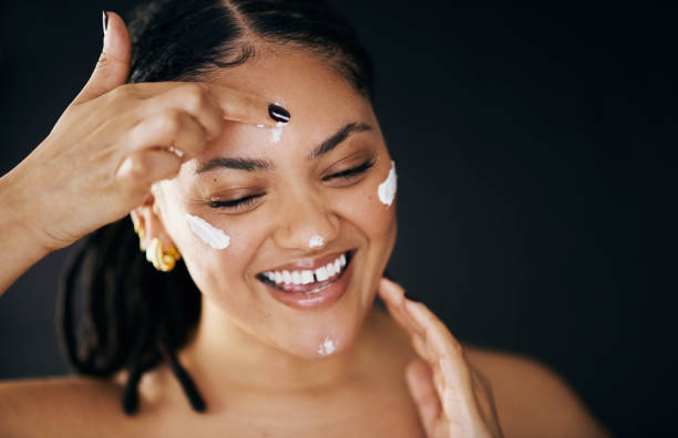istock Happy Woman Applying Face Cream in Skincare Routine 2174876457