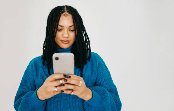 istock Connected in Blue: A Portrait of a Happy Woman with Dreadlocks Texting 2174876614