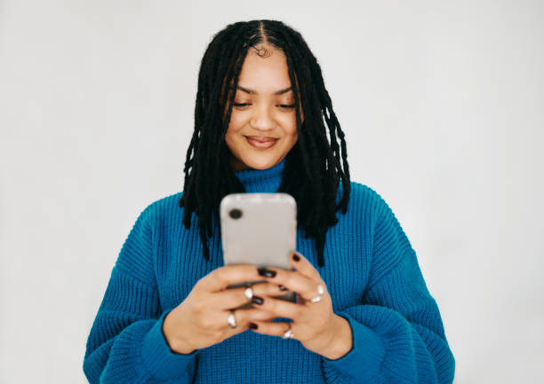 Connected in Blue: A Portrait of a Happy Woman with Dreadlocks Texting
