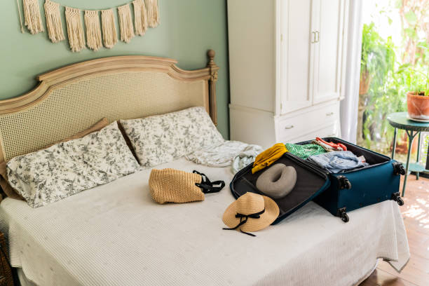 istock Suitcase with clothes and accessories on bedroom 2174877687