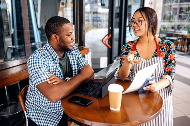 istock Asian waitress working at cafe serving regular customer and recommends something from menu 2174878319