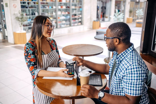 istock Asian waitress working at cafe holding credit card reader in front of regular customer 2174878616