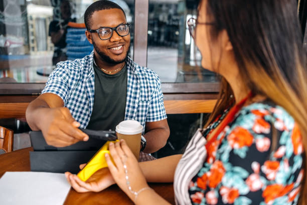 istock Asian waitress working at cafe holding credit card reader in front of regular customer 2174878700
