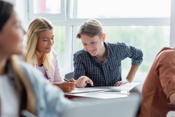 istock Engaged teens collaborating on a school project in a bright classroom during afternoon hours 2174883484