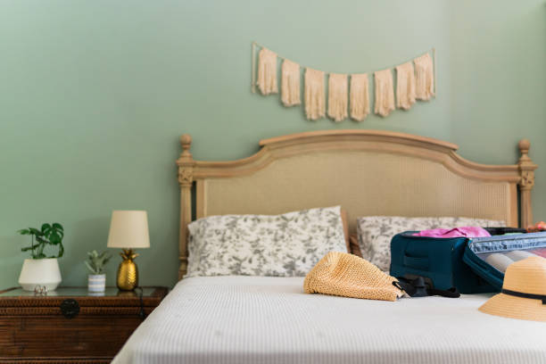 image of Wooden bed and furniture in a hotel room with white sheets and pillows, vintage bed room decor