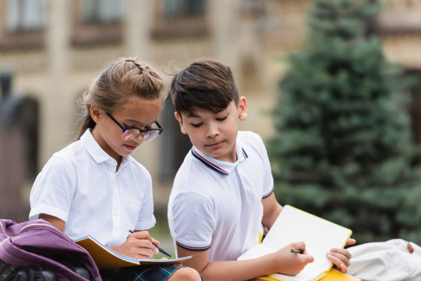 istock Kids enjoying a creative after school moment outdoors with sketchbooks and notebooks 2174885105