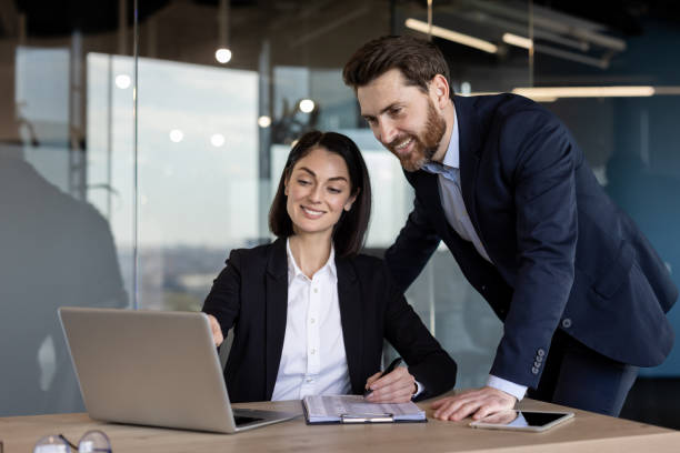 istock Business colleagues collaborating on laptop project in modern office setting with professional teamwork and positive interaction 2174885676