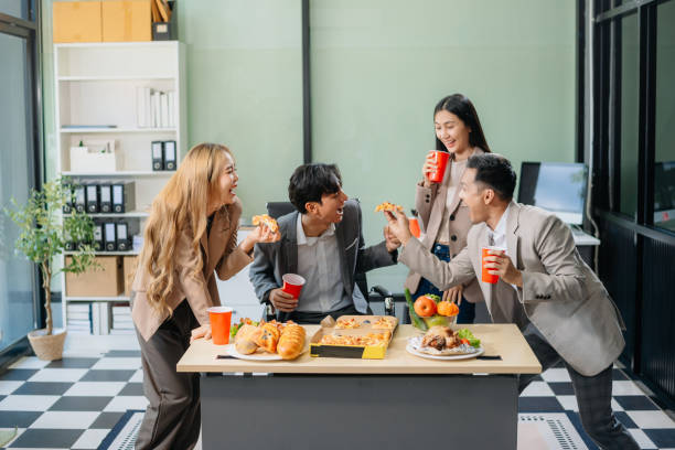 istock Young Asian Professionals Celebrating with Pizza and Drinks in a Modern Office Setting 2174890807