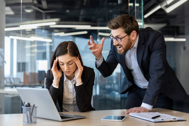 istock Angry boss shouting at stressed female office worker in modern office setting 2174891385