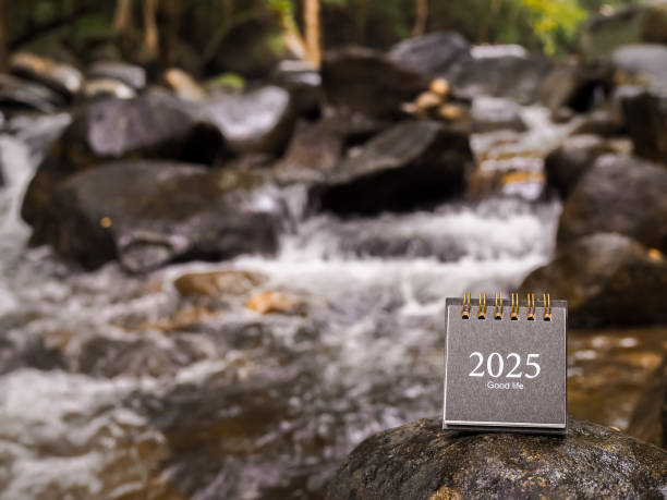 istock 2025 desk calendar on the rock with waterfall as background. Resolution, Goal, Action, Planning, and manage to success business. 2174892985
