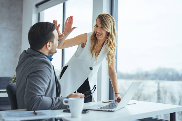 Colleagues Celebrating Success with a High Five in Modern Office