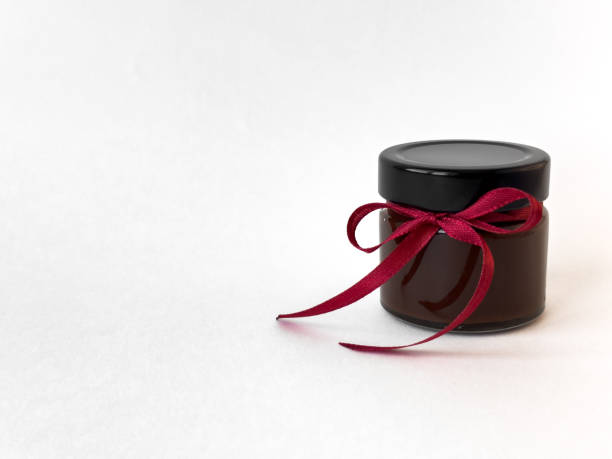 istock Elegant black jar with red ribbon on minimalist white background 2174901004