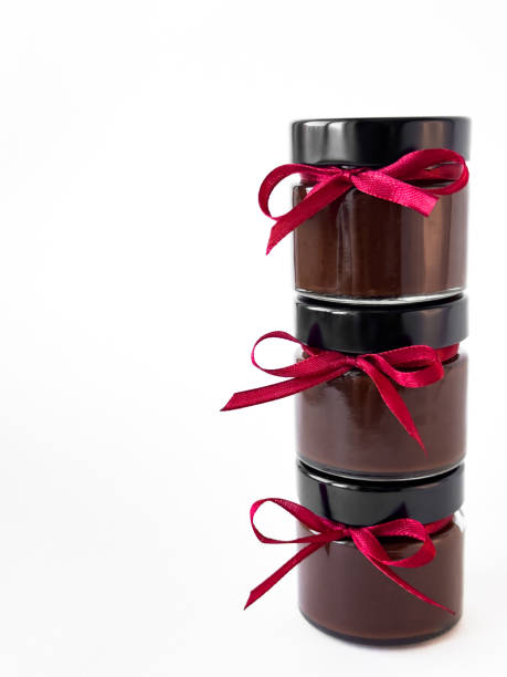 istock Stack of chocolate jars with red ribbons on white background 2174901059
