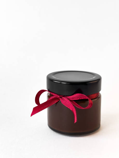 istock Elegant chocolate jar with red ribbon on white background 2174901102