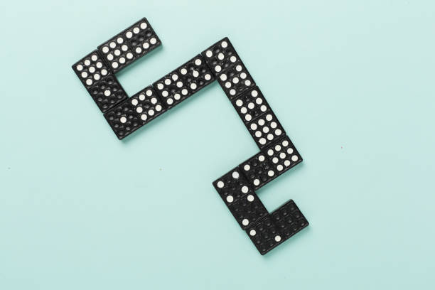 Black domino tiles on color background, top view