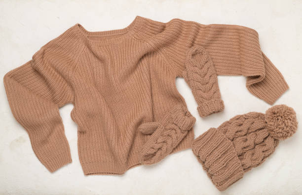 istock Sweater and winter hat with mittens on concrete background, top view. 2174901407