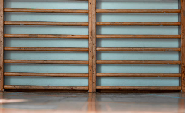 istock Wooden wall bars for gym exercises mounted on light blue wall offering sturdy structure for physical activities and training 2174903436