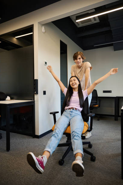 istock Freelancer is pushing his girlfriend around in an office chair 2174904292