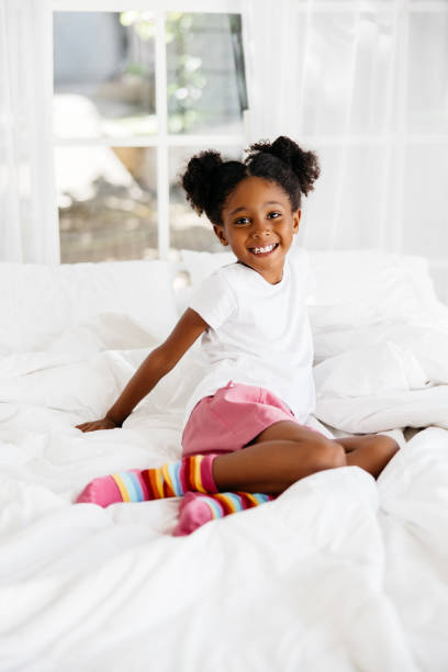 istock Young girl playing on a white bed 2174905001